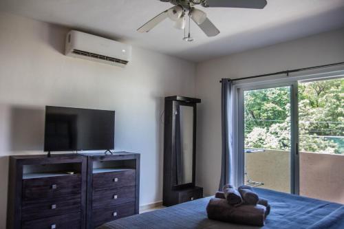 a bedroom with a bed with a television and a dresser at Creuza de Mä in Playa del Carmen