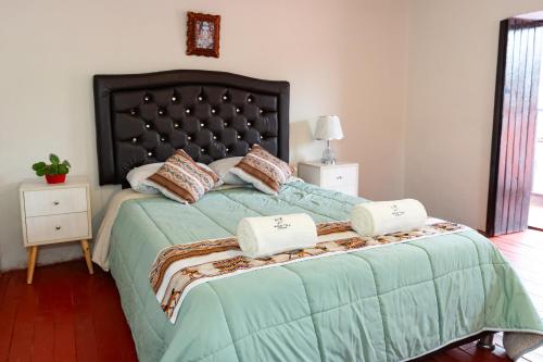 a bedroom with a bed with two pillows on it at Munay Tika house in Cusco