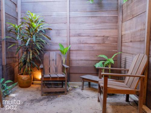 a patio with a bench and a chair and plants at Muita Paz in Atins