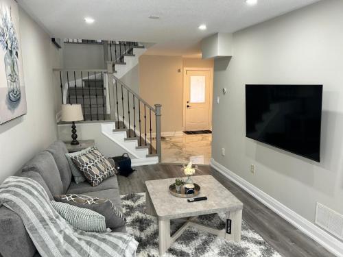 a living room with a couch and a tv at Treasure Haven Near Tourism Barrie in Barrie