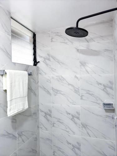 a bathroom with white marble walls and a shower at Munay Tika house in Cusco