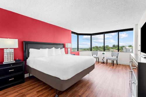 a bedroom with a large bed and a red wall at Magnolia Bluffs, BW Signature Collection in Natchez