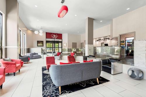 a living room with red chairs and a couch at Magnolia Bluffs, BW Signature Collection in Natchez