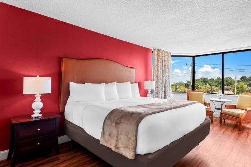 a bedroom with a large bed and a red wall at Magnolia Bluffs, BW Signature Collection in Natchez