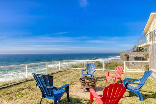 a group of chairs sitting on a balcony overlooking the ocean at Tranquil Edge Retreat - Oceanfront house w hottub in Lincoln City