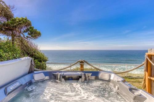 a hot tub with a view of the ocean at Tranquil Edge Retreat - Oceanfront house w hottub in Lincoln City