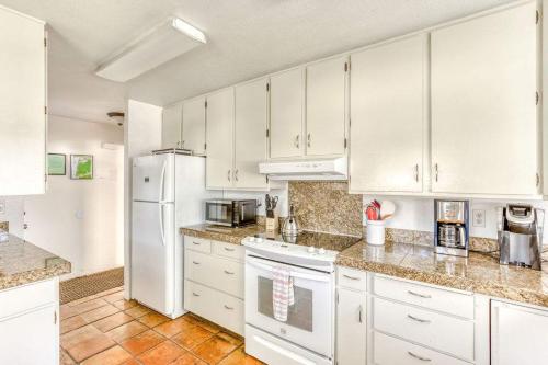 a kitchen with white cabinets and a white refrigerator at Tranquil Edge Retreat - Oceanfront house w hottub in Lincoln City