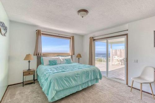 a bedroom with a bed and a large window at Tranquil Edge Retreat - Oceanfront house w hottub in Lincoln City