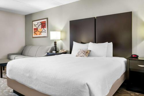 a hotel room with a large bed and a couch at Best Western Okemos/East Lansing Hotel & Suites in Okemos