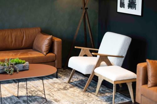 a living room with a couch and a chair at Park Inn by Radisson Antwerp City Centre in Antwerp