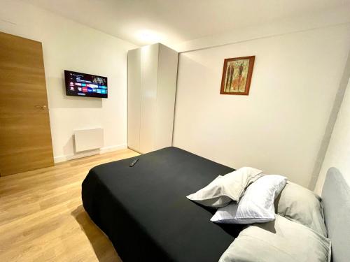 a bedroom with a bed and a tv on the wall at Flores Paradise Playa in Puerto de Sagunto