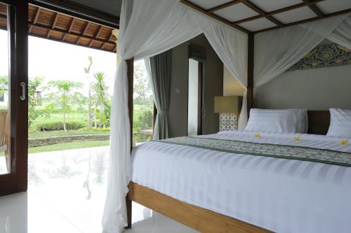 Säng eller sängar i ett rum på Masia Villa Ubud