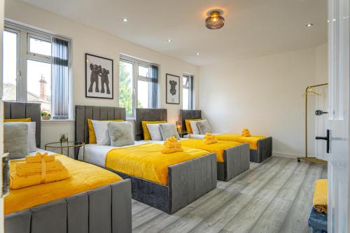 three beds in a room with yellow sheets at The Hive in Coventry