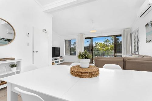 a white living room with a white table and chairs at Coastal Retreat with Marina & Ocean Views in Nelson Bay