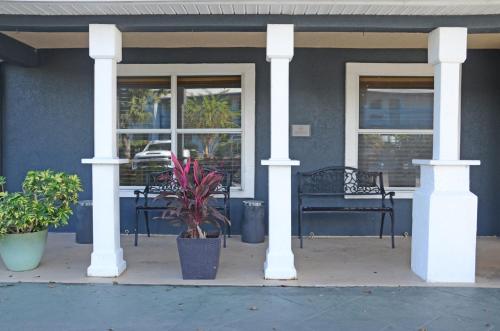 a porch with two chairs and a bench on a house at Country Inn & Suites by Radisson, Jacksonville, FL in Jacksonville