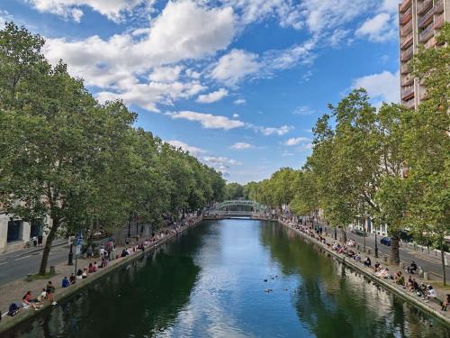 a river in a city with many people on it at Studio moderno al centro di Parigi - République in Paris