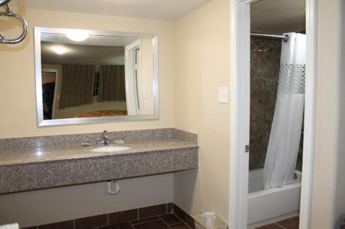 a bathroom with a sink and a mirror at American Inn & Suites in Paris