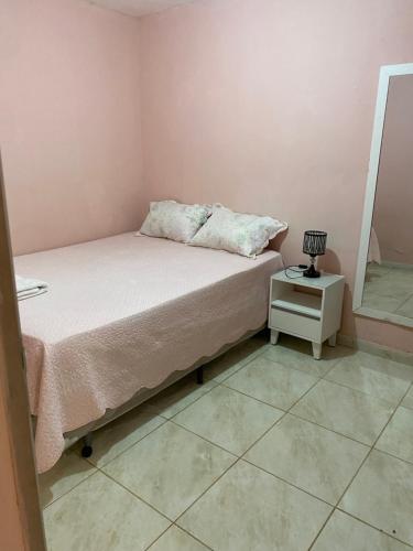 a small bedroom with a bed and a side table at Casa Aconchegante de 2 quartos e 2 cama de casal e 1 de solteir in Juazeiro do Norte