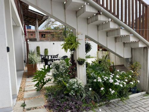 a patio with a bunch of plants and a staircase at Carolekerry Apartments in São Sebastião