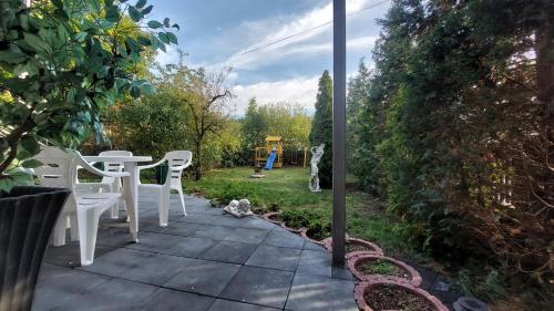 a patio with a table and chairs and a playground at Hotel Konty in Kąty Opolskie