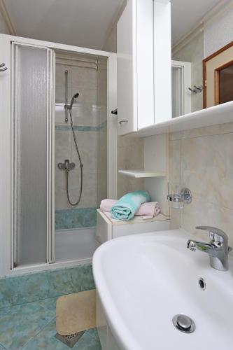 a white bathroom with a shower and a sink at Apartments with parking space Icici, Opatija - 7788 in Ičići