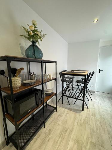 une chambre avec une table et une étagère avec un vase dans l'établissement Garden home Aulnay-sous-Bois, à Aulnay-sous-Bois