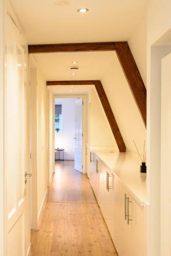 an attic hallway with white cabinets and a wooden ceiling at Spacious and attractive family home near Amsterdam in Overveen