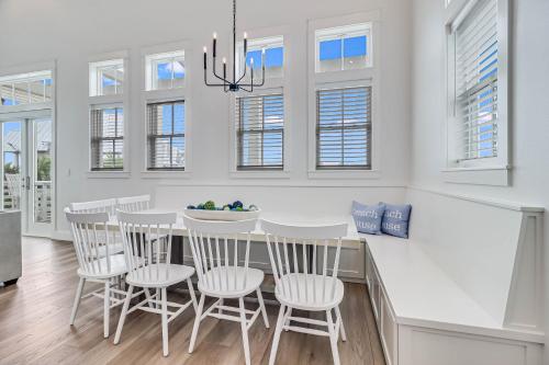 a white kitchen with a dining room table and chairs at La Belle Vue 120 BAR in Mustang Beach
