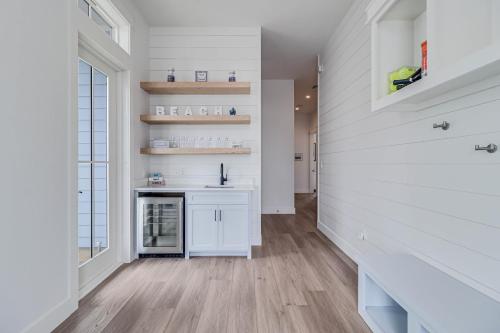 a kitchen with white walls and wooden floors at La Belle Vue 120 BAR in Mustang Beach