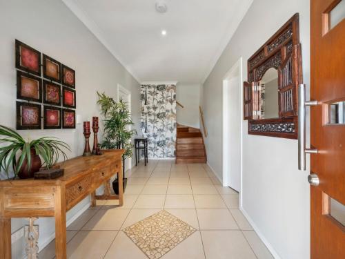 a hallway with a wooden table and a mirror at Woolgoolga Lake House in Woolgoolga