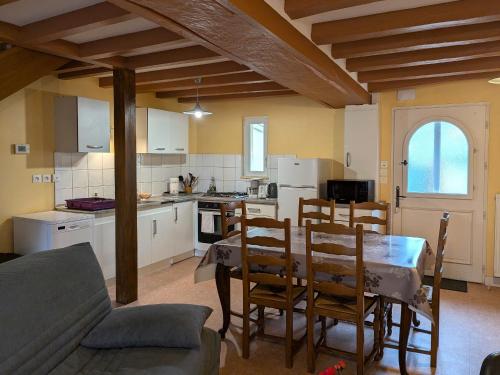 une cuisine et une salle à manger avec une table et des chaises dans l'établissement Charmant gîte solognot avec cour privative, proche commerces et nature - FR-1-590-16, à Coullons