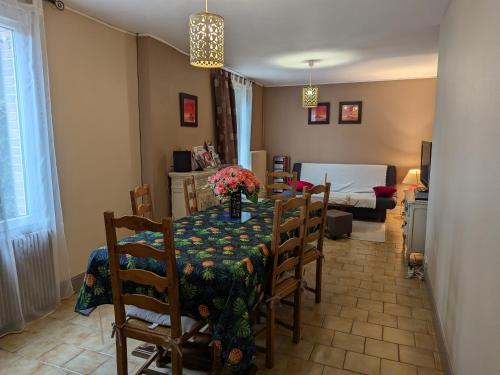 une salle à manger avec une table et des chaises et une chambre dans l'établissement Gîte charmant en Sologne : balades, pêche, visites de châteaux, animaux bienvenus - FR-1-590-100, à Villemurlin