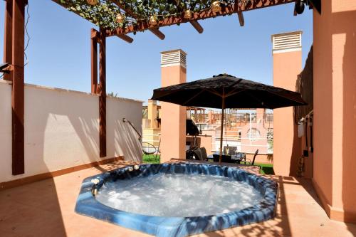 einen Whirlpool auf einer Terrasse mit Sonnenschirm in der Unterkunft Laguna Beach Relax - Terraza, Jacuzzi, Parking in Vera