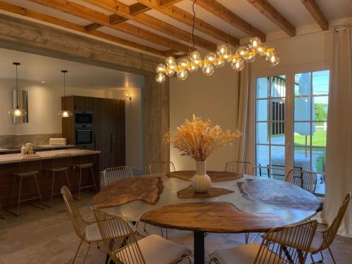 une cuisine et une salle à manger avec une table et des chaises dans l'établissement Villa Bluma, à Les Bottereaux