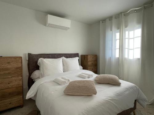 une chambre avec un lit blanc avec des serviettes dessus dans l'établissement Villa Bluma, à Les Bottereaux