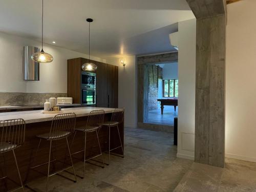 - une cuisine avec un îlot doté de chaises de bar et d'un piano dans l'établissement Villa Bluma, à Les Bottereaux