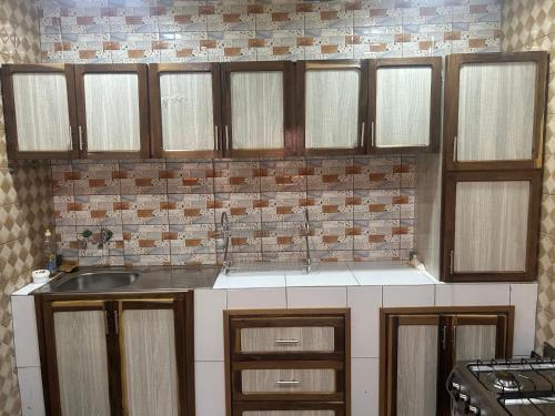 een keuken met houten kasten en een spoelbak bij Résidence Oasis in Ouagadougou