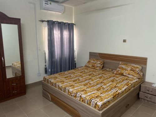 een slaapkamer met een bed in een kamer met een spiegel bij Résidence Oasis in Ouagadougou