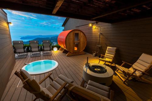 a deck with chairs and a table and a barrel at Hotel Grand Bach Atami Crescendo in Atami