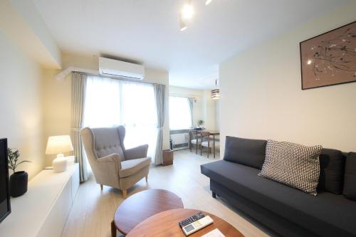 a living room with a couch and a chair at ノーザンヒルズ南6条 in Sapporo