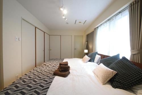 a bedroom with a large white bed and a window at ノーザンヒルズ南6条 in Sapporo