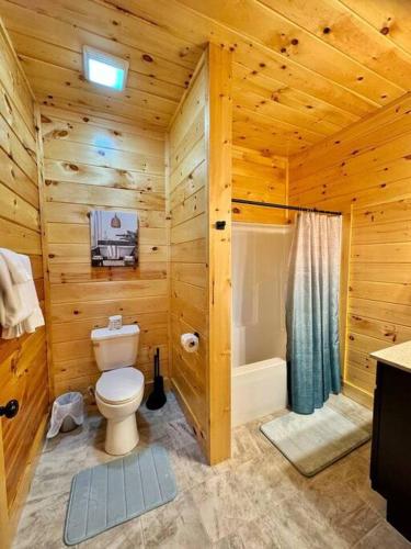 a log cabin bathroom with a toilet and a shower at Enchanted Peak Lodge in Pigeon Forge