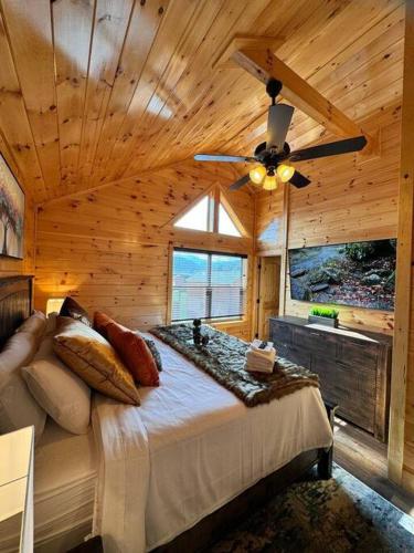 a bedroom with a large bed and a ceiling fan at Enchanted Peak Lodge in Pigeon Forge