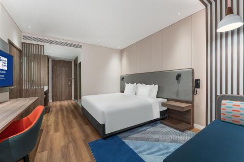 a hotel room with a white bed and a tv at Holiday Inn Express Chengdu Pidu by IHG in Chengdu