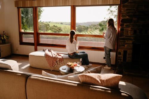 two women standing in a living room looking out the window at Chapel Hill Winery Guest House in McLaren Vale