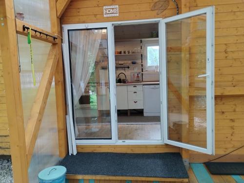 a door to a kitchen in a tiny house at Včelín in Morávka