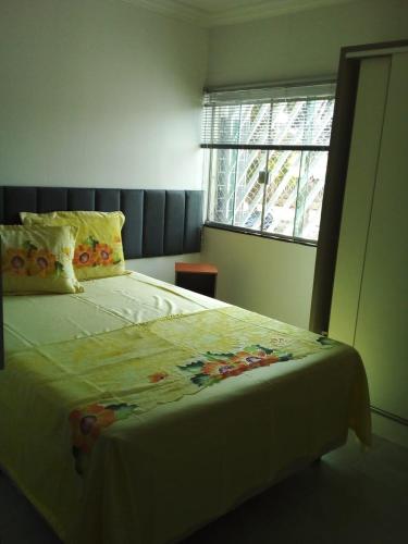 a bedroom with a large bed with a window at Apto 2 quartos Nucleo Bandeirante in Brasília
