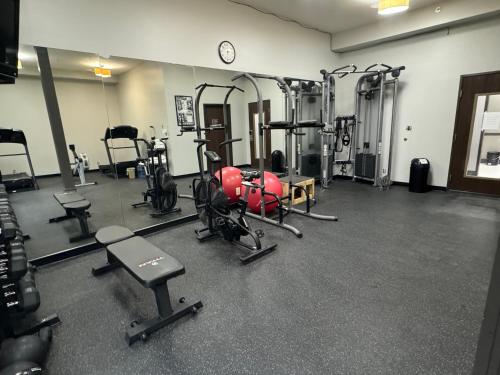 a gym with several tread machines and a clock at Brentwood Suites Nashville, an Ascend Collection Hotel in Brentwood
