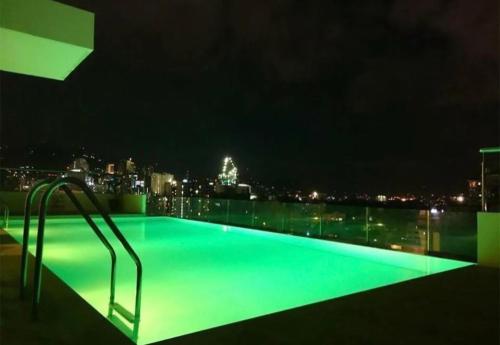 a swimming pool at night with a city in the background at Mabolo Garden Flats Bnb in Cebu City