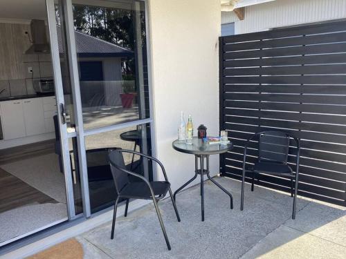a small table and chairs on a patio at Xanadu - A restful place in Bunnythorpe